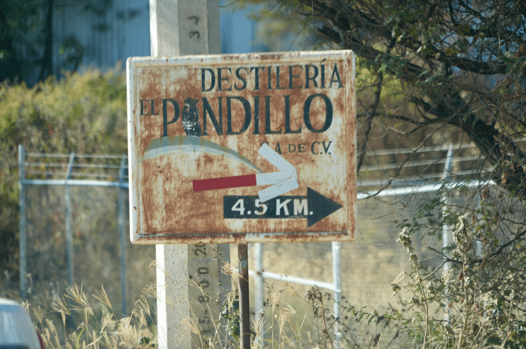 Sign for Destilería El Pandillo, pointing the way for unique wine country getaways.