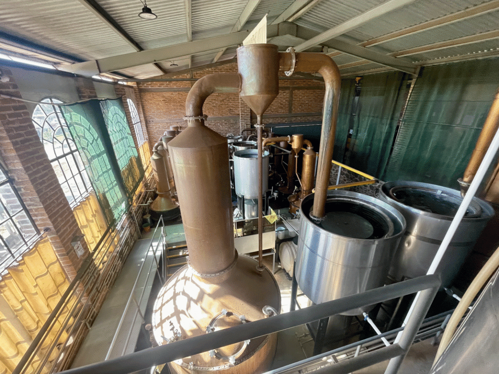 Copper stills and tanks inside a distillery, showcasing a VIP Winery Vacations experience.